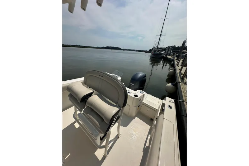 Slide: The Image of 2022 Sailfish 220 CC boat docked, featuring comfortable seating and a serene waterfront view. - 19