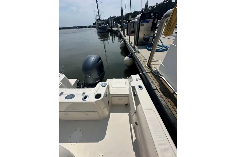 Slide: The Image of 2022 Sailfish 220 CC boat docked at marina with outboard motor. - 21