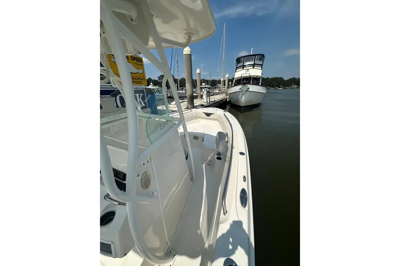 Slide: The Image of 2022 Sailfish 220 CC boat docked in a marina under clear blue skies. - 28