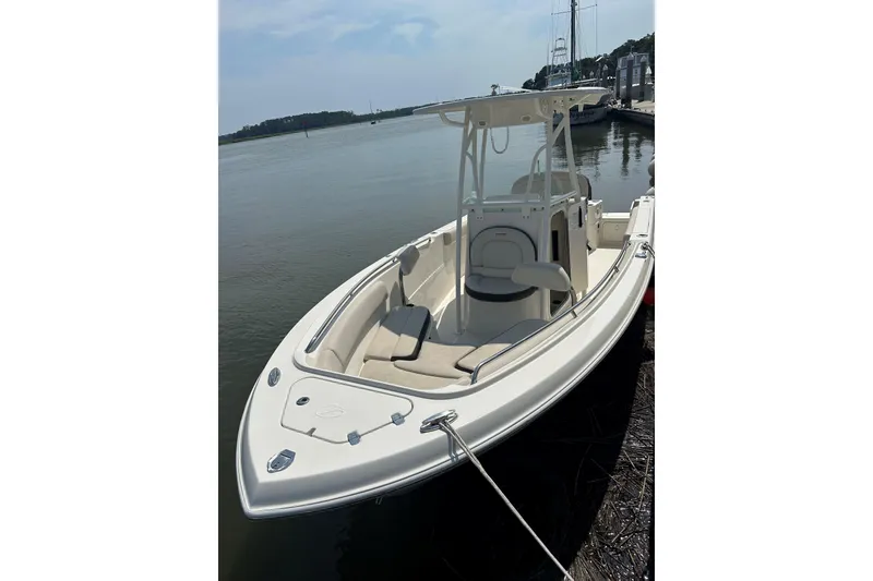 Slide: The Image of 2022 Sailfish 220 CC boat docked by calm waters, showcasing sleek design and spacious seating. - 31