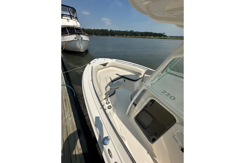 Slide: The Image of 2022 Sailfish 220 CC boat docked on calm water, sunny day. - 32