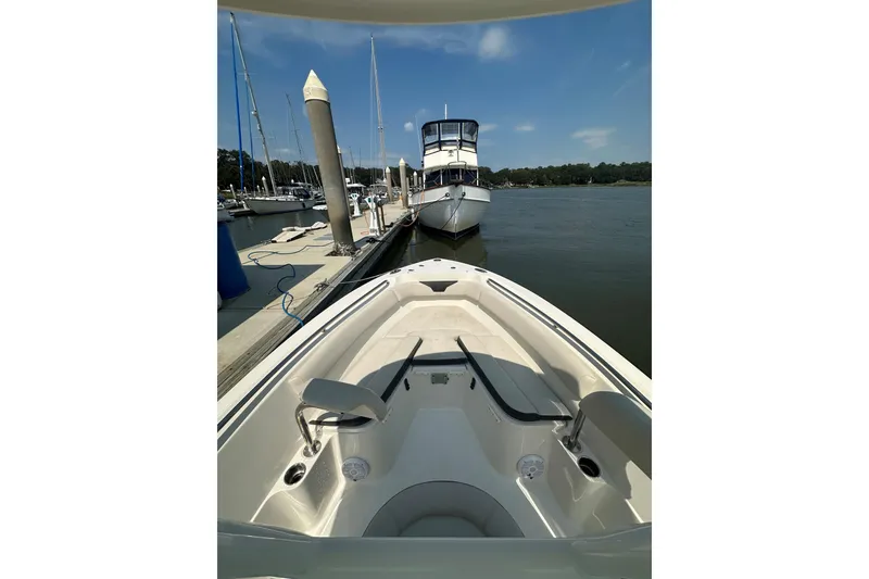 Slide: The Image of 2022 Sailfish 220 CC boat docked at marina, clear sky, calm water. - 33