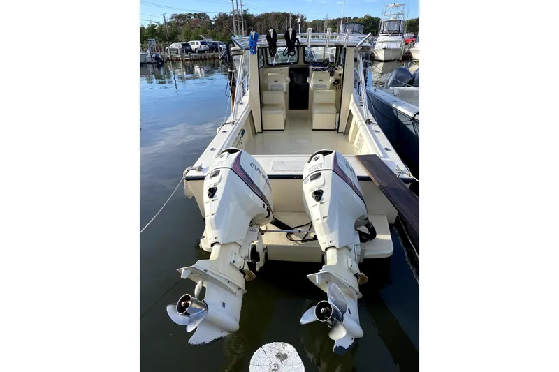 Slide: The Image of 2005 Maycraft 2700 Pilothouse with dual outboard motors docked at marina. - 3