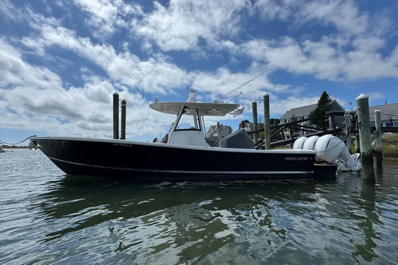 Slide: The Image of 2023 Regulator 34 Center Console boat docked by waterfront homes. - 0