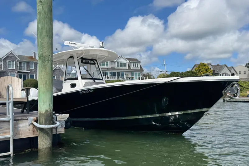 Slide: The Image of 2023 Regulator 34 Center Console boat docked on a sunny day. - 1