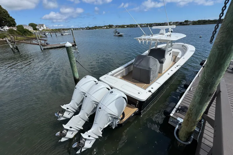 Slide: The Image of 2023 Regulator 34 Center Console boat docked with triple outboard engines. - 12