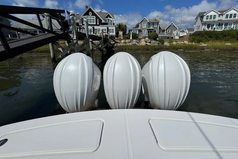 Slide: The Image of 2023 Regulator 34 Center Console with triple outboard engines near waterfront homes. - 13