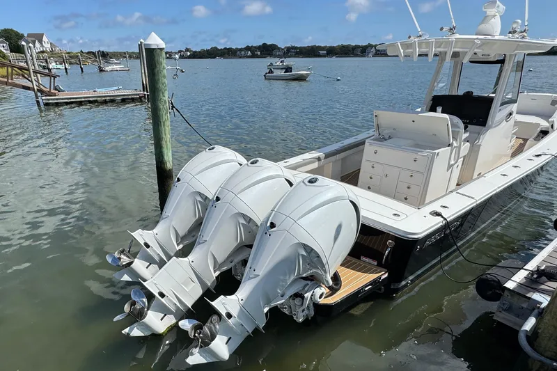 Slide: The Image of 2023 Regulator 34 Center Console boat docked with triple outboard engines. - 15
