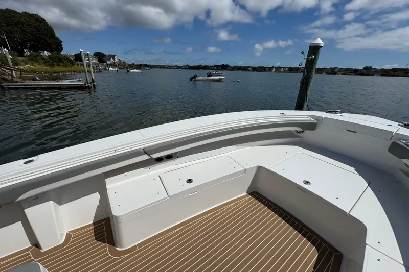 Slide: The Image of 2023 Regulator 34 Center Console boat on calm water, featuring spacious seating and scenic view. - 18