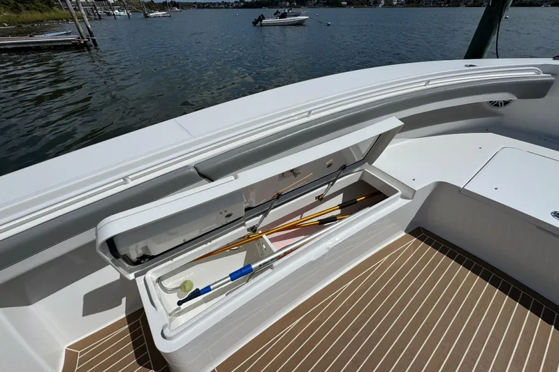 Slide: The Image of 2023 Regulator 34 Center Console boat with open storage compartment, docked by the water. - 19