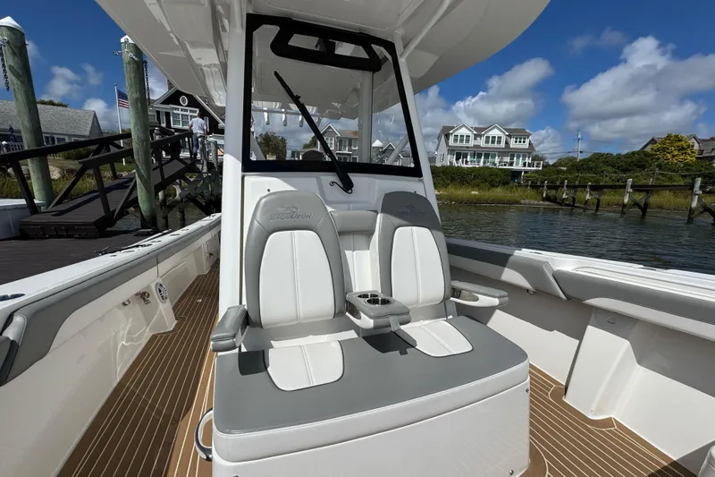 Slide: The Image of 2023 Regulator 34 Center Console boat interior with dual seats and scenic waterfront view. - 25