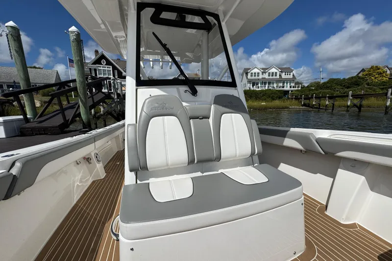 Slide: The Image of 2023 Regulator 34 Center Console boat interior with seating, docked near waterfront homes. - 26