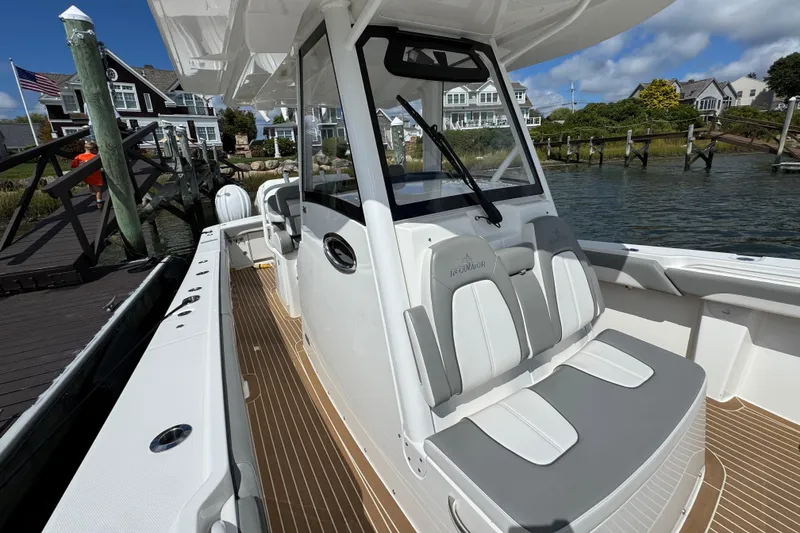 Slide: The Image of 2023 Regulator 34 Center Console boat docked near waterfront homes. - 32
