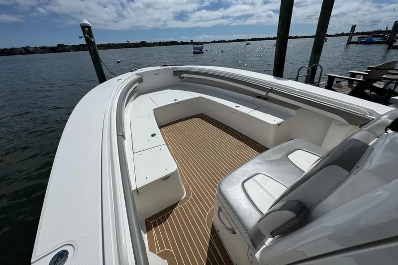 Slide: The Image of 2023 Regulator 34 Center Console boat with spacious seating, docked by the water. - 34