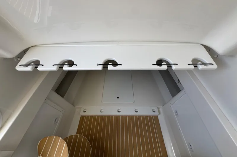 Slide: The Image of 2023 Regulator 34 Center Console interior with rod holders and teak flooring. - 36