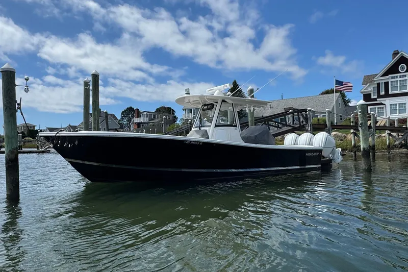 Slide: The Image of 2023 Regulator 34 Center Console boat docked in a scenic marina. - 4
