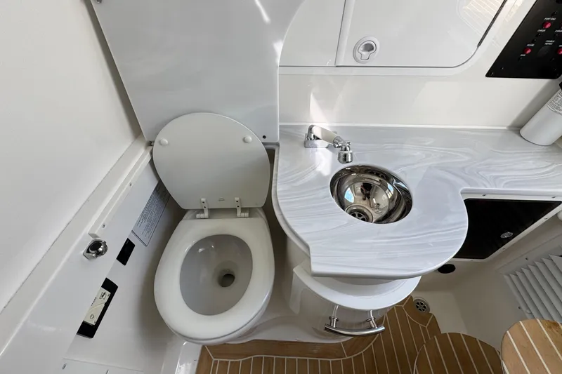 Slide: The Image of 2023 Regulator 34 Center Console bathroom with toilet and modern sink design. - 41