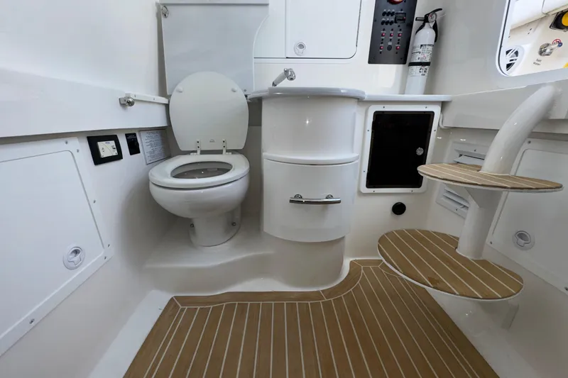 Slide: The Image of 2023 Regulator 34 Center Console boat interior with toilet and wooden steps. - 43
