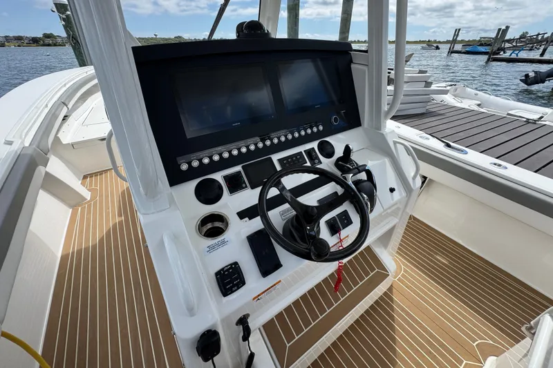 Slide: The Image of 2023 Regulator 34 Center Console boat helm with dual screens and steering wheel. - 48