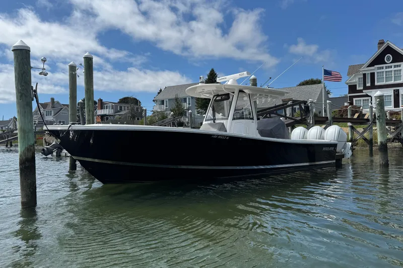 Slide: The Image of 2023 Regulator 34 Center Console boat docked near waterfront homes. - 5