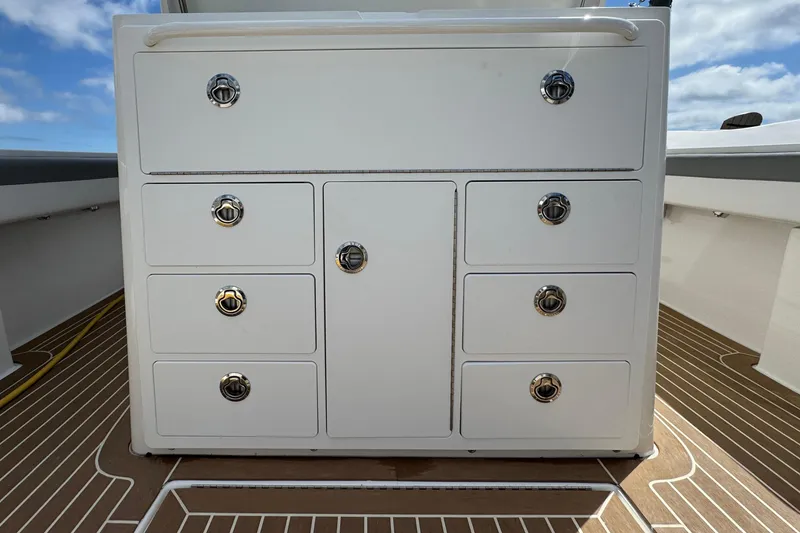Slide: The Image of 2023 Regulator 34 Center Console storage unit with multiple drawers on a boat deck. - 60