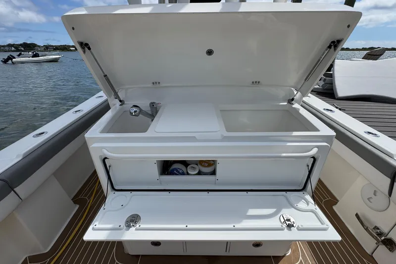 Slide: The Image of 2023 Regulator 34 Center Console boat with open storage compartments and sink. - 65