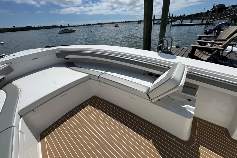 Slide: The Image of 2023 Regulator 34 Center Console boat with spacious seating, docked by a scenic waterfront. - 68
