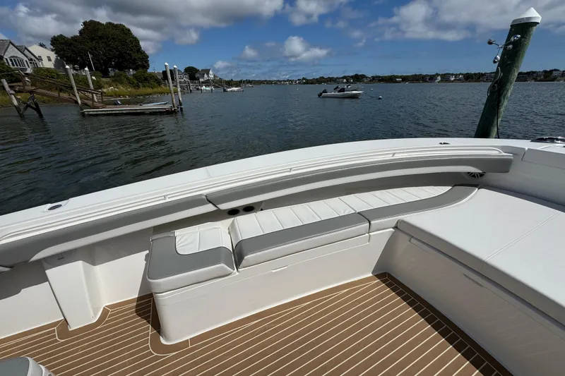 Slide: The Image of 2023 Regulator 34 Center Console boat with spacious seating, docked by a scenic waterfront. - 69