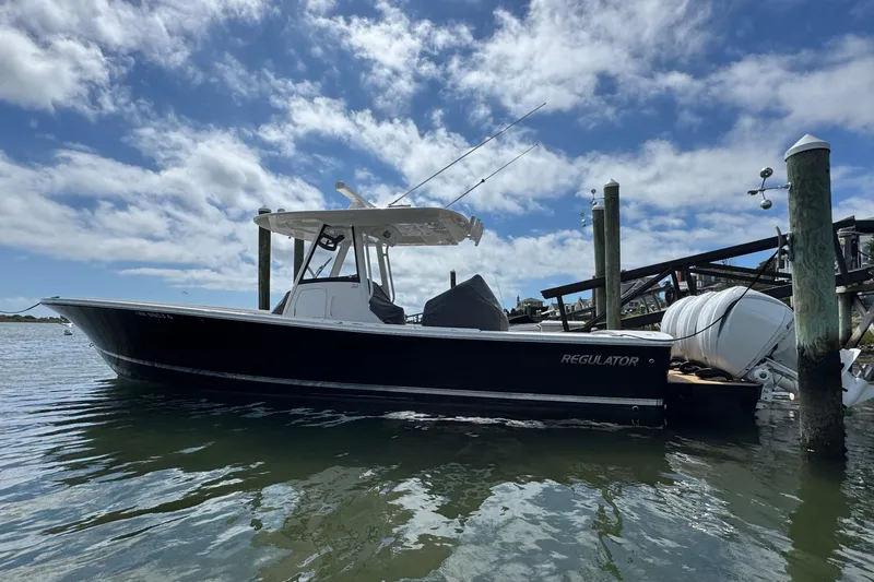 Slide: The Image of 2023 Regulator 34 Center Console boat docked under a partly cloudy sky. - 7