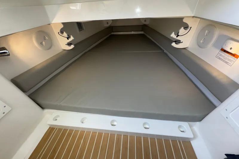 Slide: The Image of 2023 Regulator 34 Center Console cabin interior with cushioned seating and wood flooring. - 74