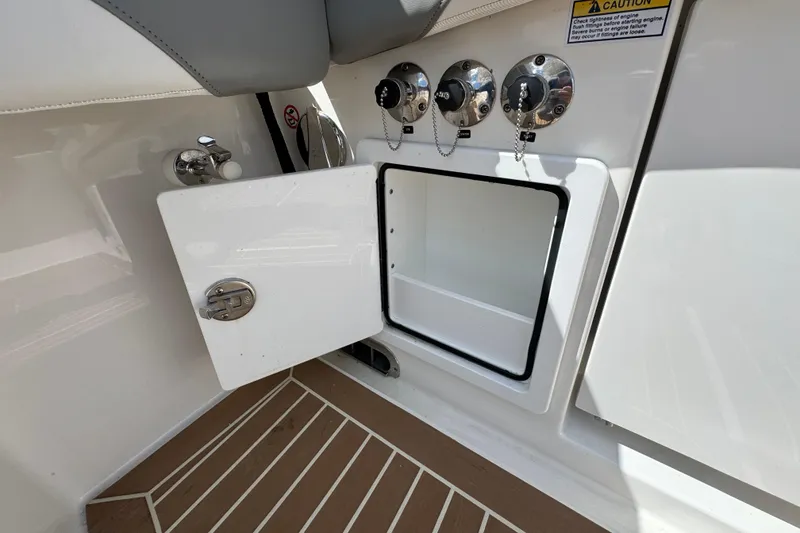 Slide: The Image of 2023 Regulator 34 Center Console storage compartment with open hatch and control panel. - 87