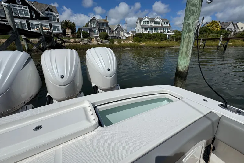 Slide: The Image of 2023 Regulator 34 Center Console boat with triple engines docked near waterfront homes. - 89