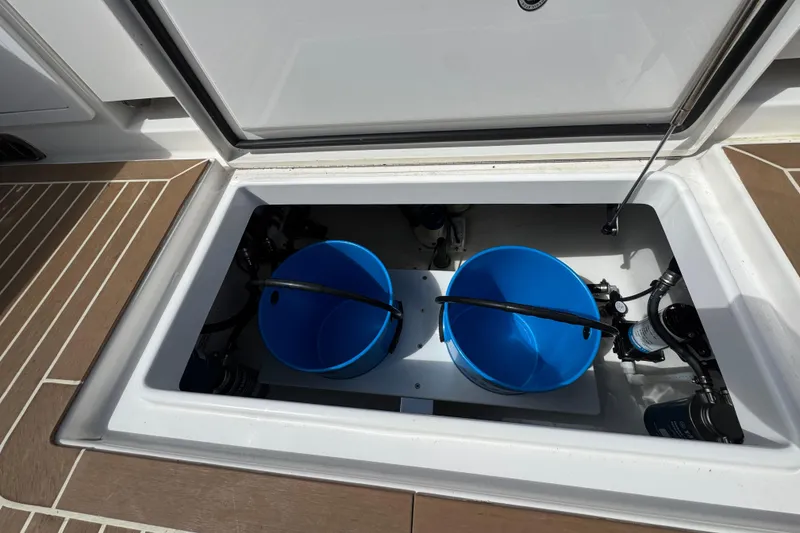Slide: The Image of 2023 Regulator 34 Center Console storage compartment with blue buckets and equipment. - 95