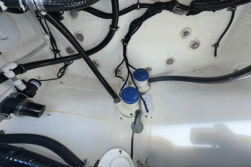 Slide: The Image of 2023 Regulator 34 Center Console bilge area with wiring and pumps. - 96