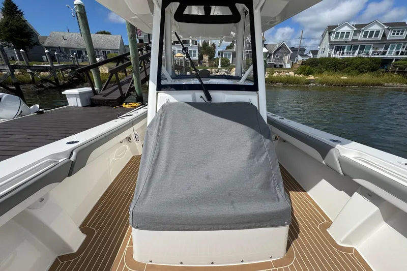 Slide: The Image of 2023 Regulator 34 Center Console boat docked, featuring covered seating and waterfront homes. - 98