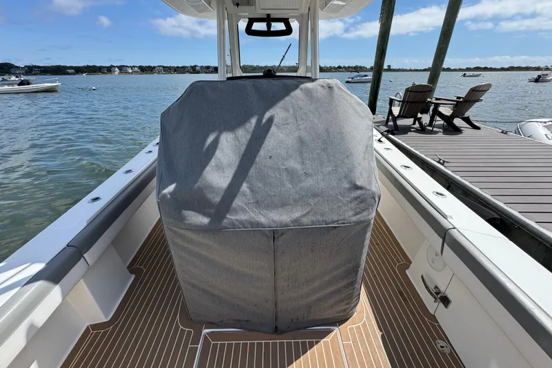 Slide: The Image of 2023 Regulator 34 Center Console boat with covered helm, docked by a scenic waterfront. - 99