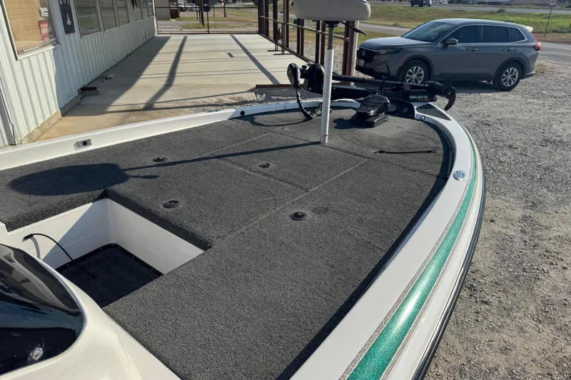 Slide: The Image of 2000 Skeeter ZX200 boat with carpeted deck and trolling motor in parking area. - 10