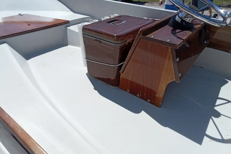 Slide: The Image of 1985 Boston Whaler 150 Sport interior with wooden console and steering wheel. - 12