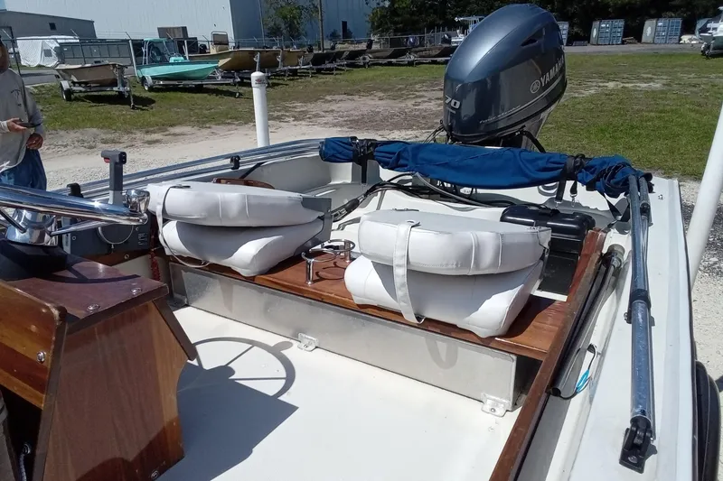 Slide: The Image of 1985 Boston Whaler 150 Sport boat with Yamaha outboard motor, featuring white seating and wooden accents. - 14