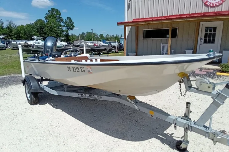 Slide: The Image of 1985 Boston Whaler 150 Sport boat on trailer, parked outside a building. - 3