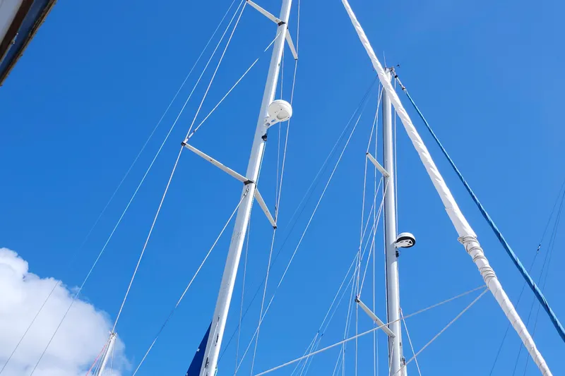 Slide: The Image of Masts of a 2001 Bavaria 43 Cruiser sailboat against a clear blue sky. - 15