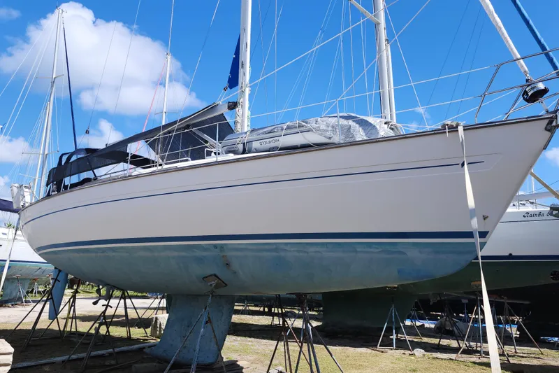 Slide: The Image of Bavaria 43 Cruiser 2001 sailboat on land, blue sky background, ready for maintenance. - 2