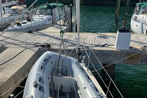 Slide: The Image of Docked Bavaria 42 sailboat from 2001 with inflatable dinghy, marina setting. - 25