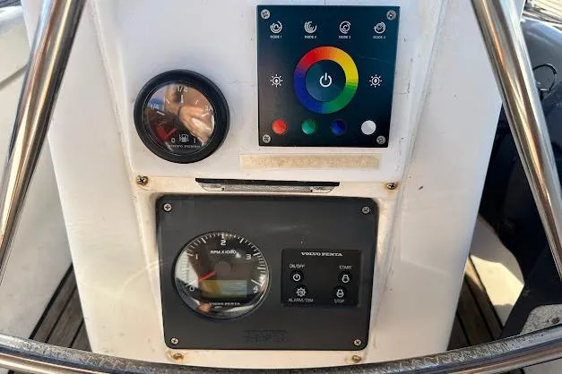 Slide: The Image of Control panel of a 2001 Bavaria 42 sailboat with gauges and color-coded buttons. - 27