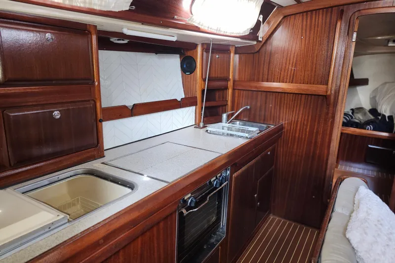 Slide: The Image of Interior of 2001 Bavaria 43 Cruiser yacht kitchen with wooden cabinetry and modern appliances. - 29