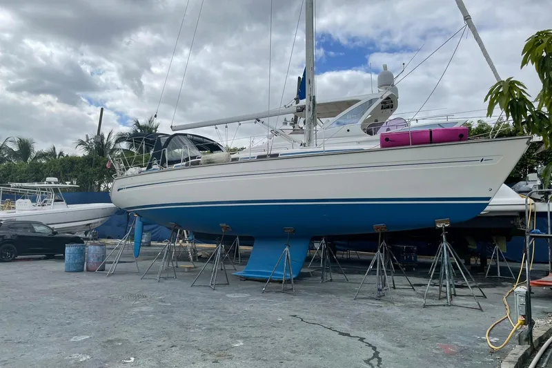Slide: The Image of Bavaria 43 Cruiser 2001 sailboat on stands in a boatyard, under cloudy skies. - 3