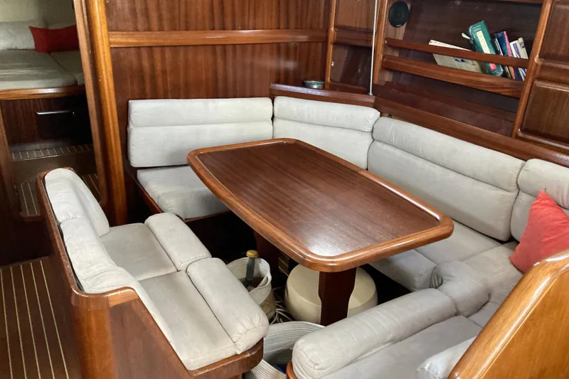 Slide: The Image of Cozy interior of 2001 Bavaria 43 Cruiser yacht with wooden dining area and cushioned seating. - 40