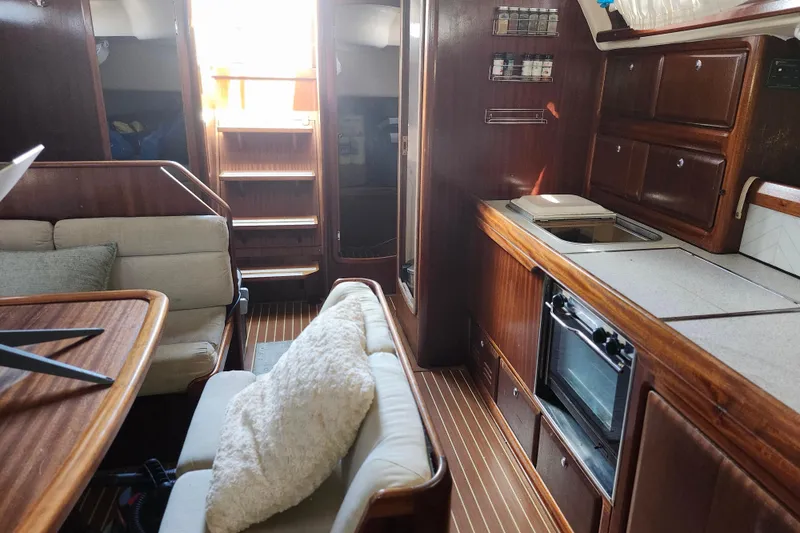 Slide: The Image of Interior of 2001 Bavaria 43 Cruiser yacht with wooden cabinetry and cozy seating area. - 42