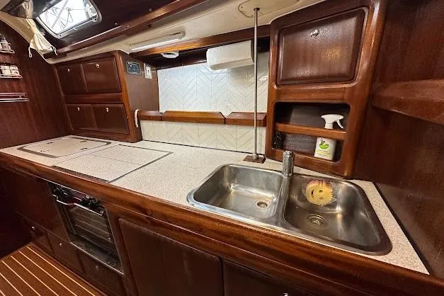 Slide: The Image of Galley kitchen in 2001 Bavaria 42 sailboat with wood cabinetry and stainless steel sink. - 47