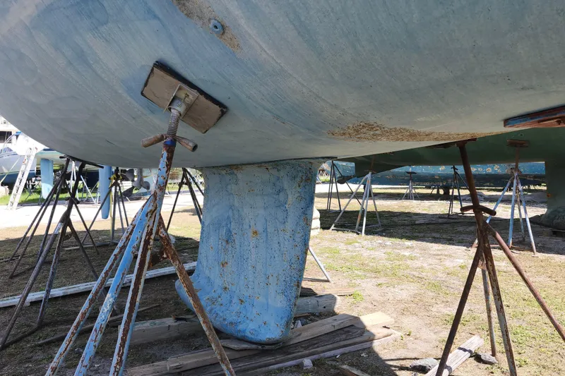 Slide: The Image of Bavaria 43 Cruiser 2001 sailboat keel supported by stands in a boatyard. - 5